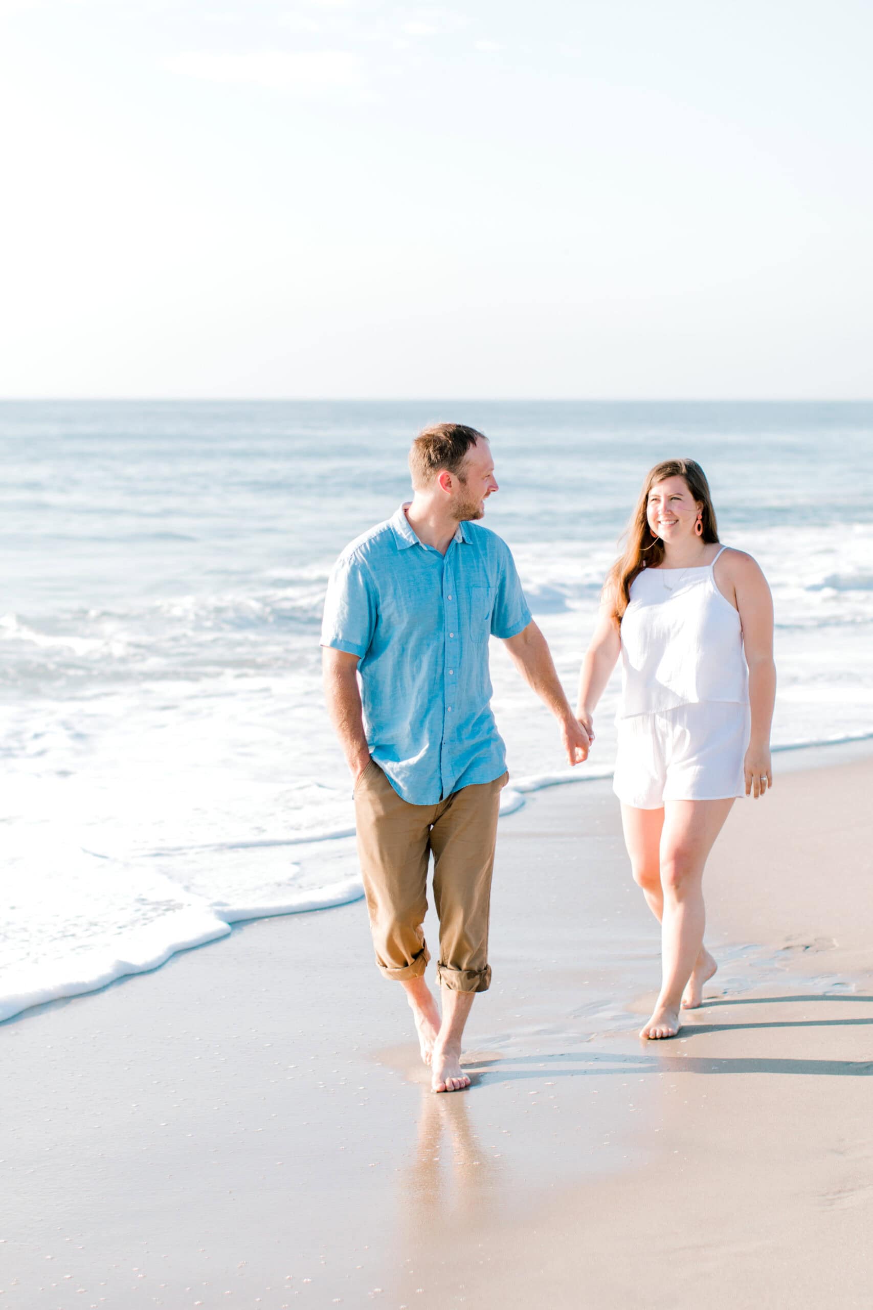 Romantic beach couple photoshoot at sunset, capturing love and happiness by the ocean.